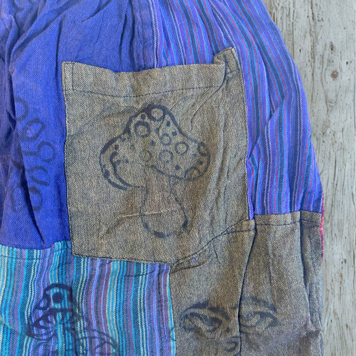 Detailansicht der aufgesetzten Tasche mit handgestempeltem Pilz-Blockprint auf der Freizeithose.